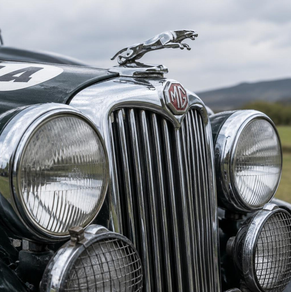 Detail shot of a vintage rally car's chrome grille and headlights